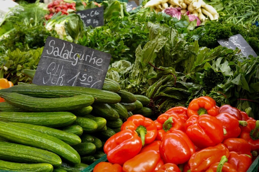 Vibrant fresh vegetables including cucumbers and peppers on a market stand.