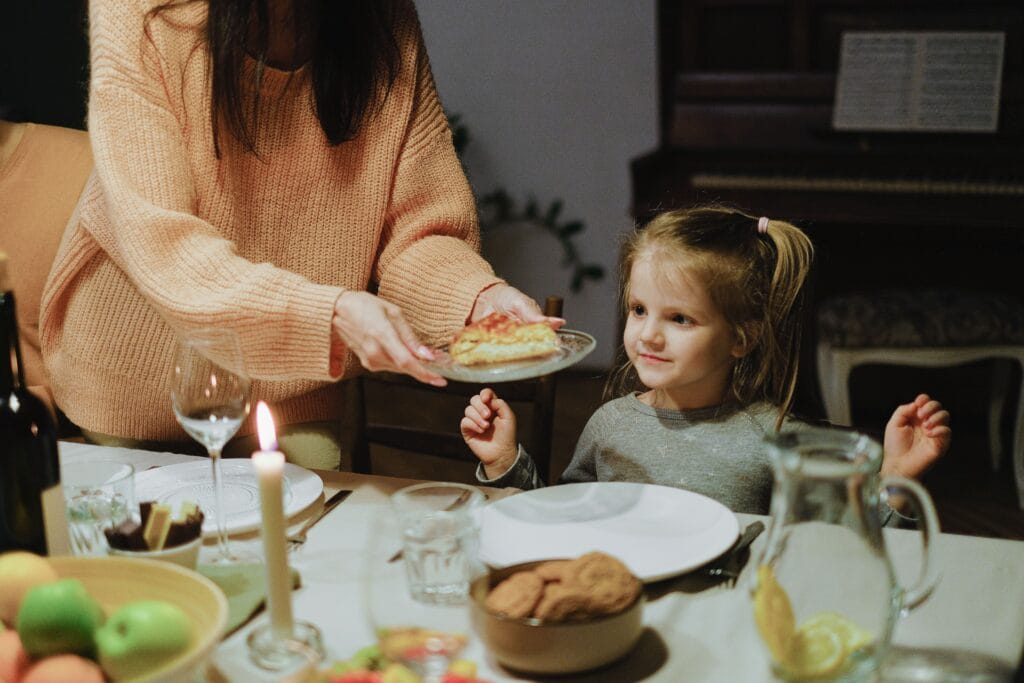 Familie genießt gemeinsam ein histaminarmes Abendessen am Esstisch – stressfreies Familienessen für einen ruhigen Schlaf.